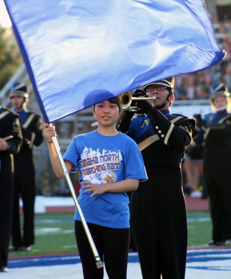 Junna Nozaki, 12, holds the flag for color guard at the North vs. Burke football game on September 14, 2018. Japan does not have color guard or football, so these are new experiences for Nozaki. Photo by Caitlin Pieters