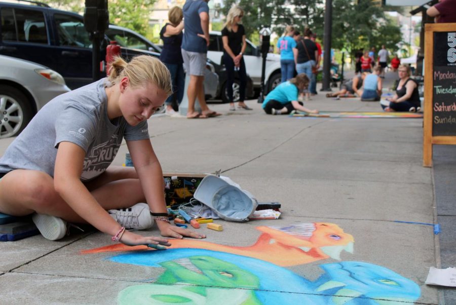 Emily Quackenbush blends colors together on her artwork for the chalk drawing competition at Midtown Crossing on Saturday, September 14. Quackenbush has been drawing since elementary school and uses it as a form of self-expression. 