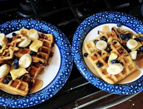 Two plates of waffles sit atop the stove, both served with bananas, blueberries and syrup. Katie Long, 12, enjoys making these waffles with her mom.
PHOTO BY KATIE LONG