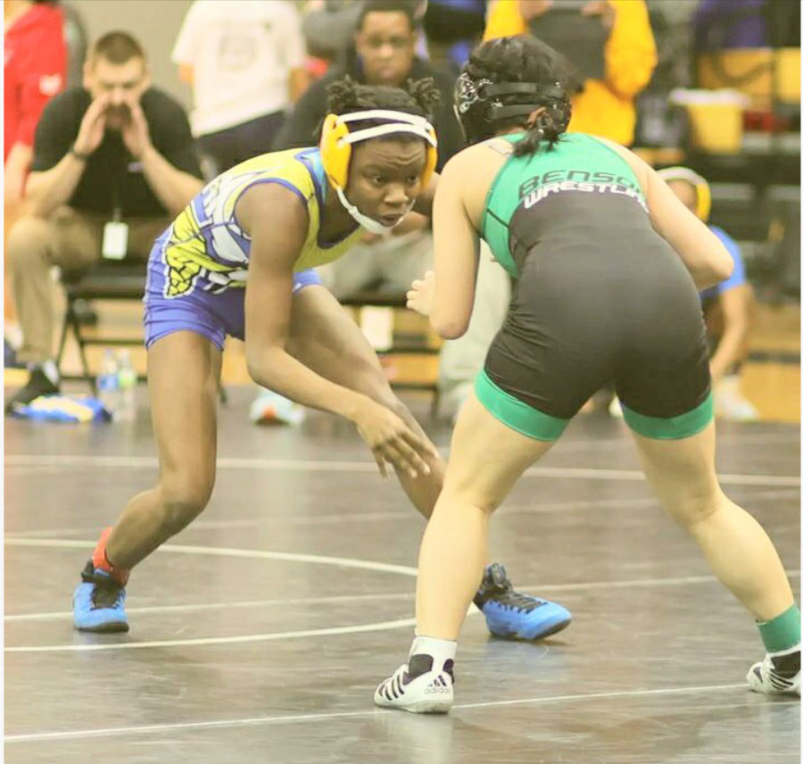 Chelsey+Robinson%2C+10%2C+stands+on+the+wrestling+mat+with+her+opponent.+Robinson+has+been+on+the+wrestling+team+since+last+year.+